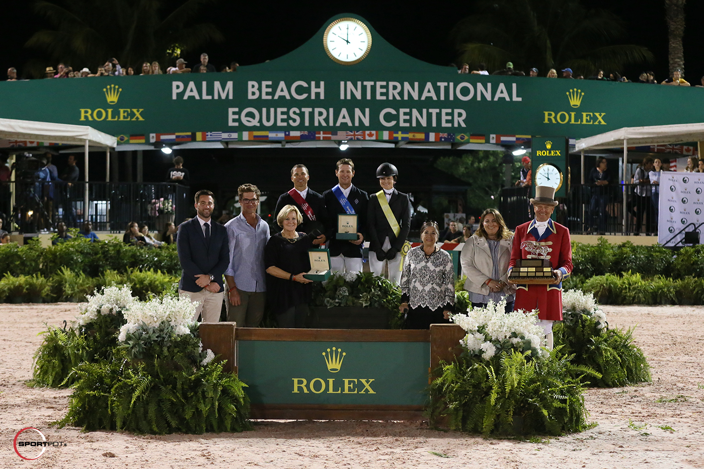 Kent Farrington, McLain Ward, and Lucy Deslauriers on the podium, joined by Kyle Younghans, Sports Marketing Manager of Rolex Watch USA, Quentin Judge, Jeannie Harrison, Marsha Dammerman, Cayce Harrison, and ringmaster Steve Rector. Photo © Sportfot